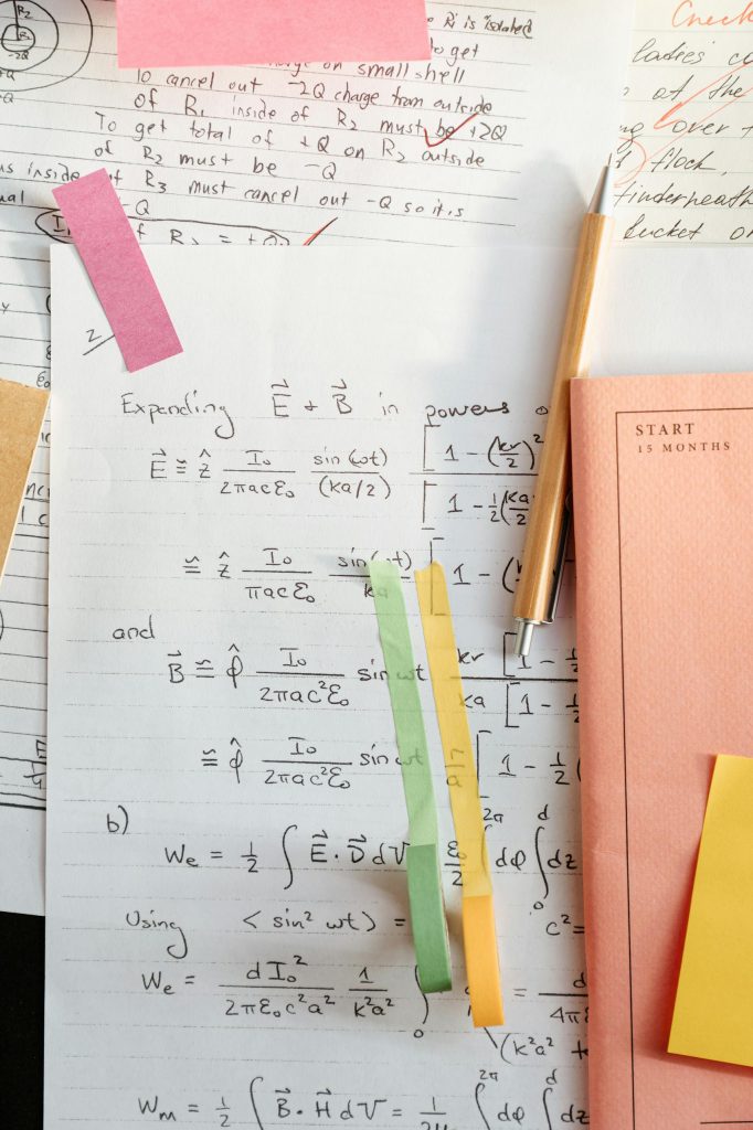 Detailed math notes with handwritten equations and colorful papers, perfect for educational use.